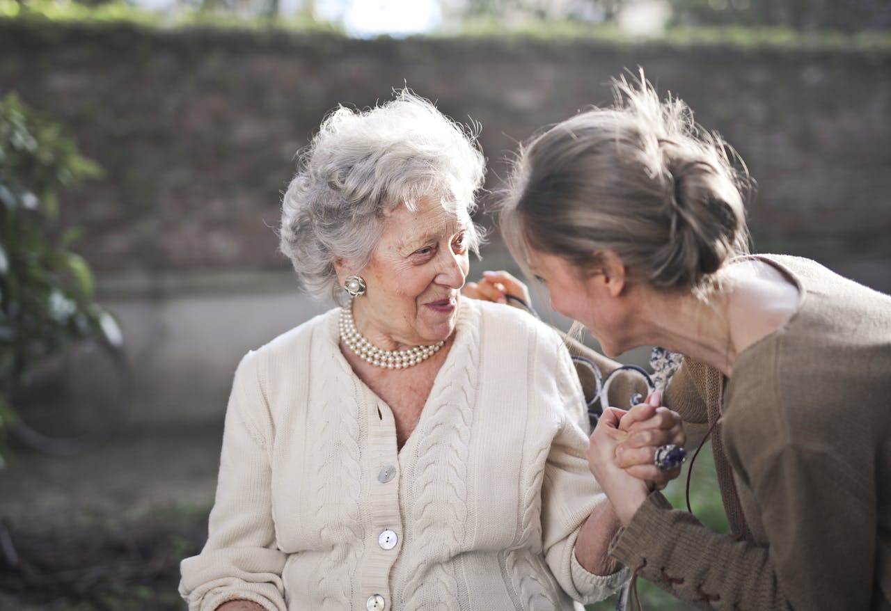 story-02 Joyful interaction between an elderly woman and her granddaughter in a sunny outdoor setting.